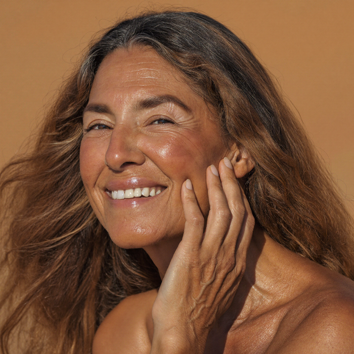 Smiling woman in her late fifties with a warm, radiant complexion